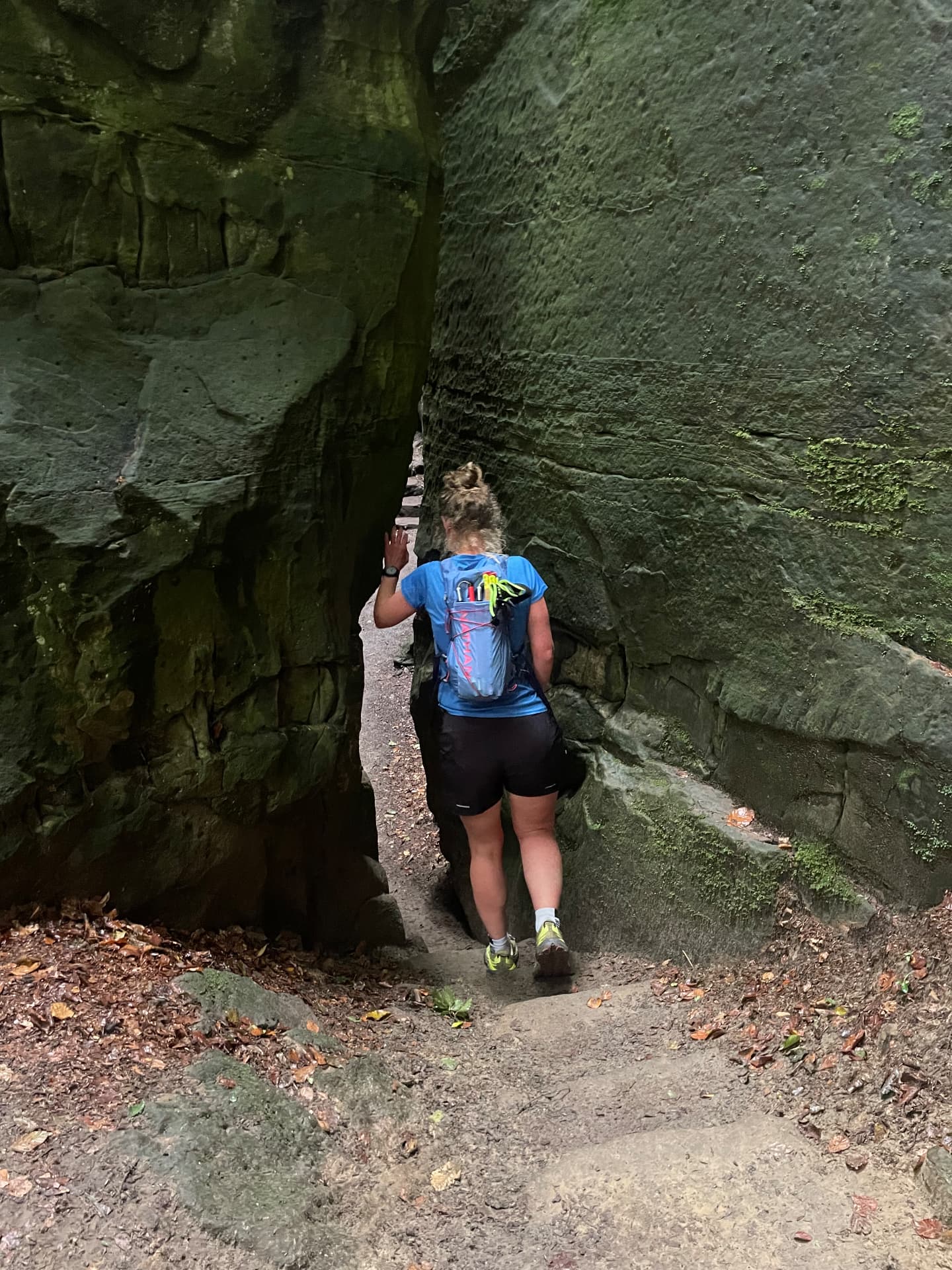 Vrouw daalt af over een rotsachtig bospad tijdens een trailrun