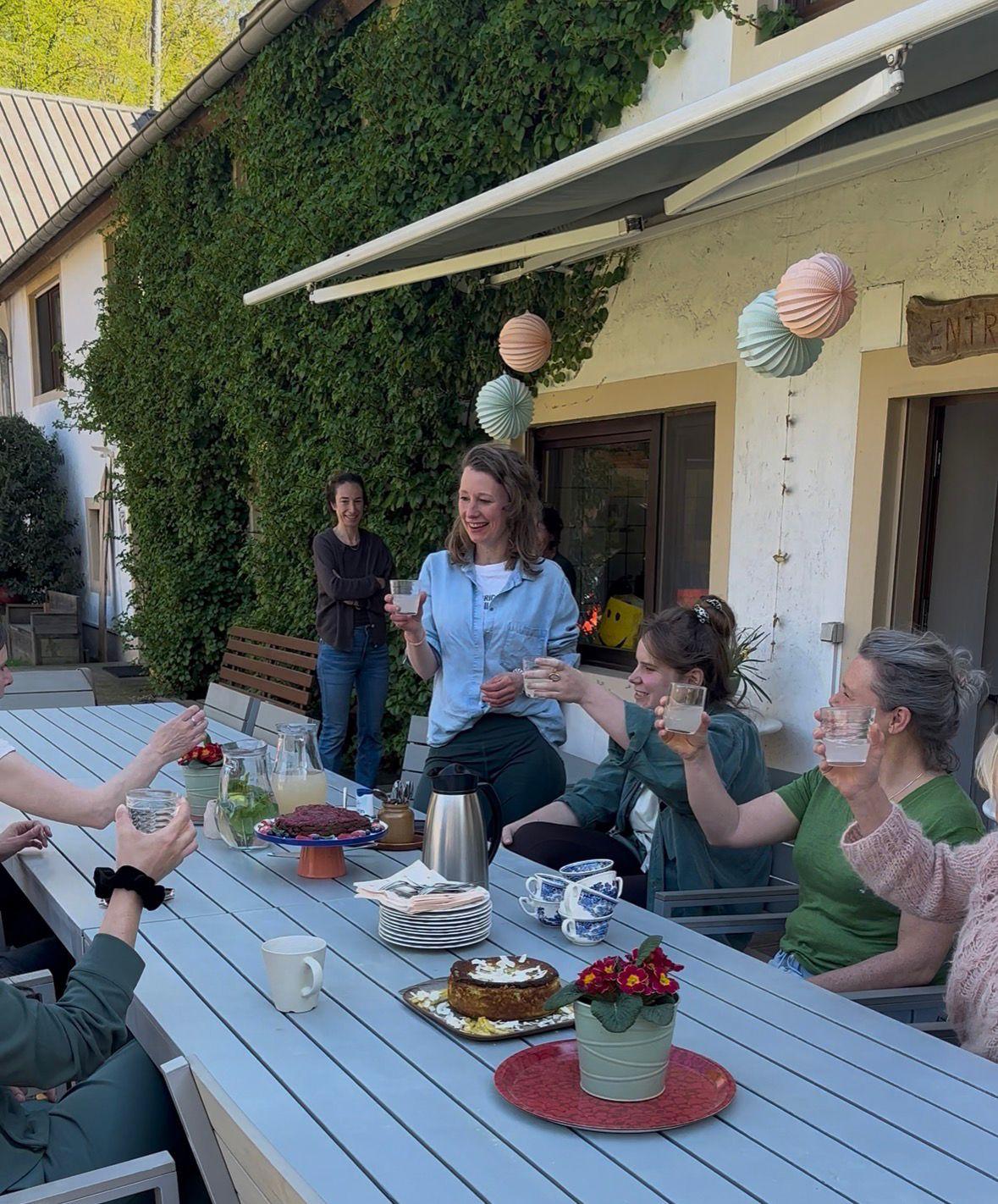Vrouwen toosten samen aan een gedekte tafel in de buitenlucht